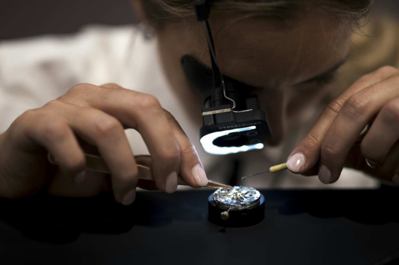 Travail de précision sur le stand de l'horloger suisse IWC, filiale du groupe Richemont, lors du salon de l'horlogerie de luxe à Genève, le 1er avril 2025 © Fabrice COFFRINI