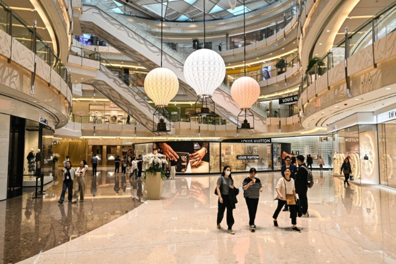 Des personnes marchent dans le centre commercial IFC, dans le quartier financier de Shanghai, le 9 avril 2025. © Hector RETAMAL