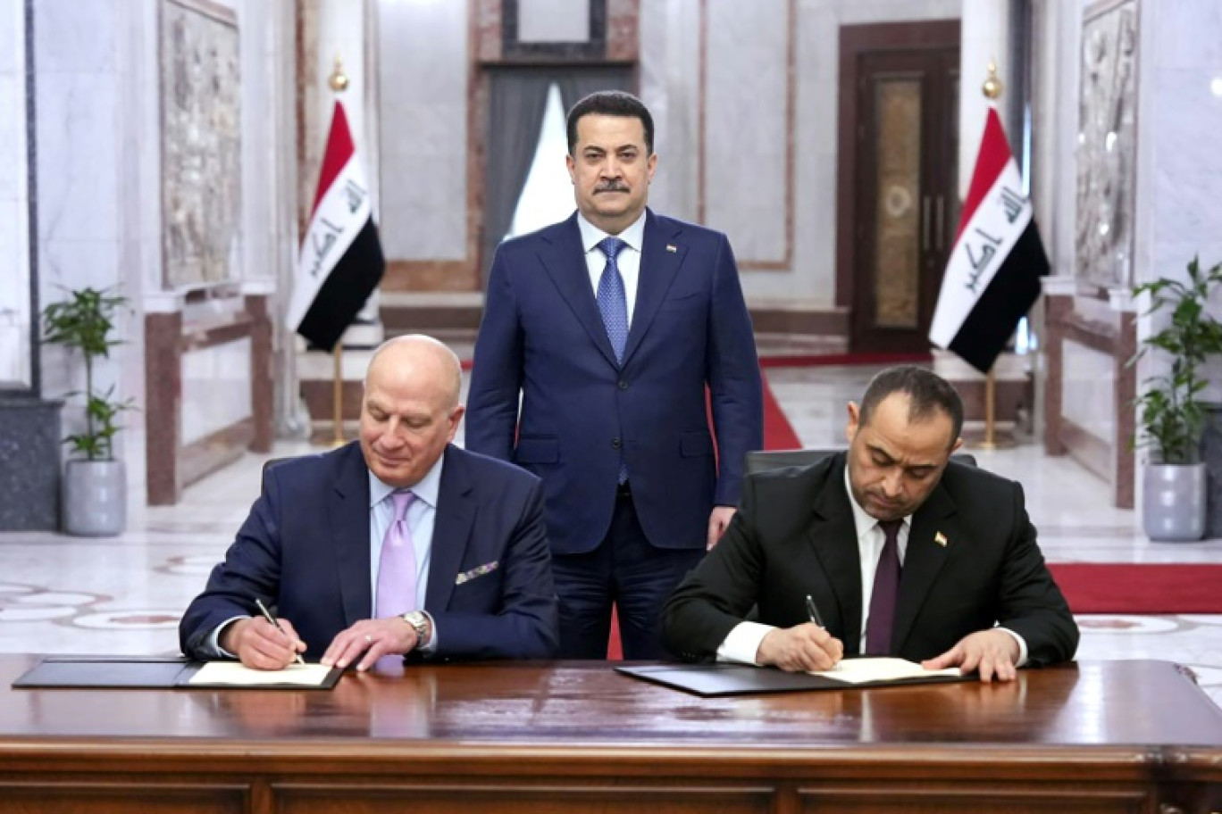 Le Premier ministre irakien Mohamed Chia al-Soudani (c) assiste à la signature d'un mémorandum d'entente avec le géant de l'énergie américain GE VERNOVA pour des centrales électriques au gaz et la production de 24.000 mégawatts d'électricité, le 9 avril 2025 à Bagdad © -