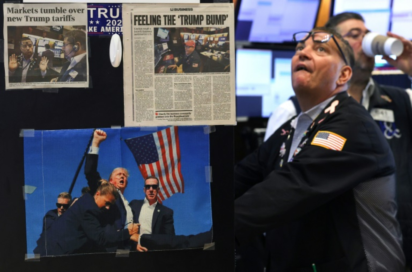 Des coupures de presse et une image du président américain Donald Trump affichées sur un bureau alors que les traders travaillent sur le parquet de la Bourse de New York (NYSE) à la cloche d'ouverture, le 9 avril 2025 à New York © TIMOTHY A. CLARY