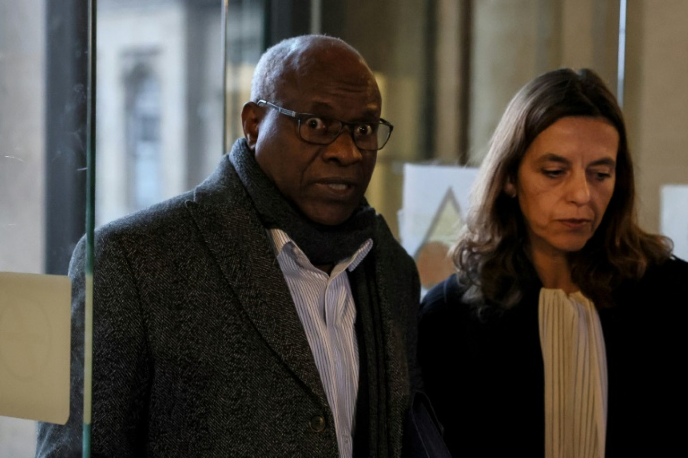 L'ancien médecin rwandais Sosthène Munyemana (g), arrive avec son avocate Florence Bourg au palais de justice de Paris pour son procès pour génocide et crimes contre l'humanité lors des massacres de 1994 au Rwanda, le 14 novembre 2023 © ALAIN JOCARD