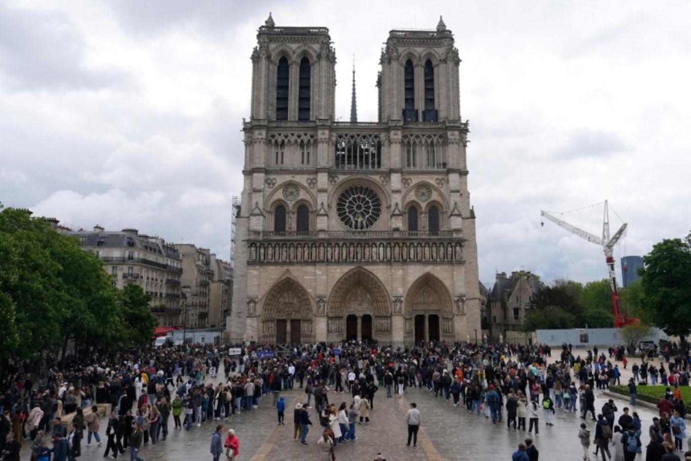 Des personnes rassemblées devant la cathédrale Notre-Dame de Paris, le 21 avril 2025 © Dimitar DILKOFF