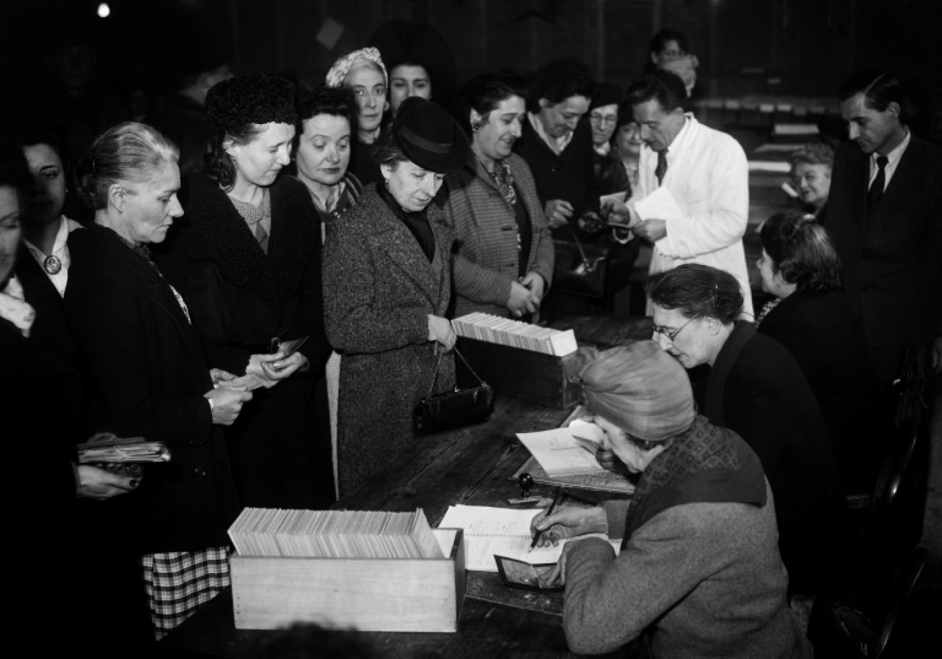 Des femmes reçoivent leur bulletin de vote pour la première fois en France lors des élections municipales à Paris, le 29 avril 1945 © -