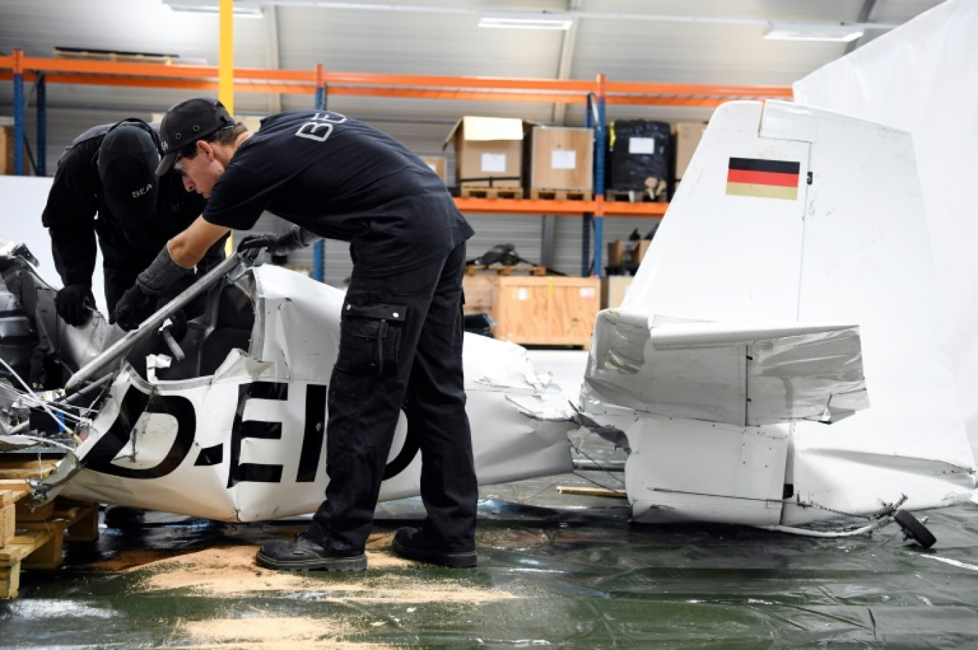 Des techniciens du BEA examinent l'épave d'un avion écrasé dans un hangar du siège du BEA, le 11 septembre 2018, au Bourget en Seine-Saint-Denis © ALAIN JOCARD