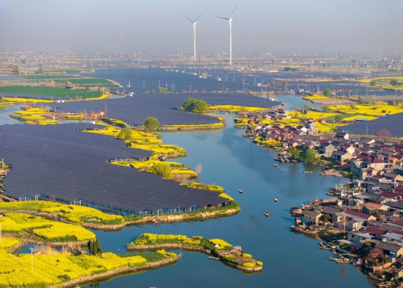 Des panneaux solaires et des éoliennes dans un village de Taizhou, dans la province orientale du Jiangsu en Chine, le 26 mars 2025 © STR