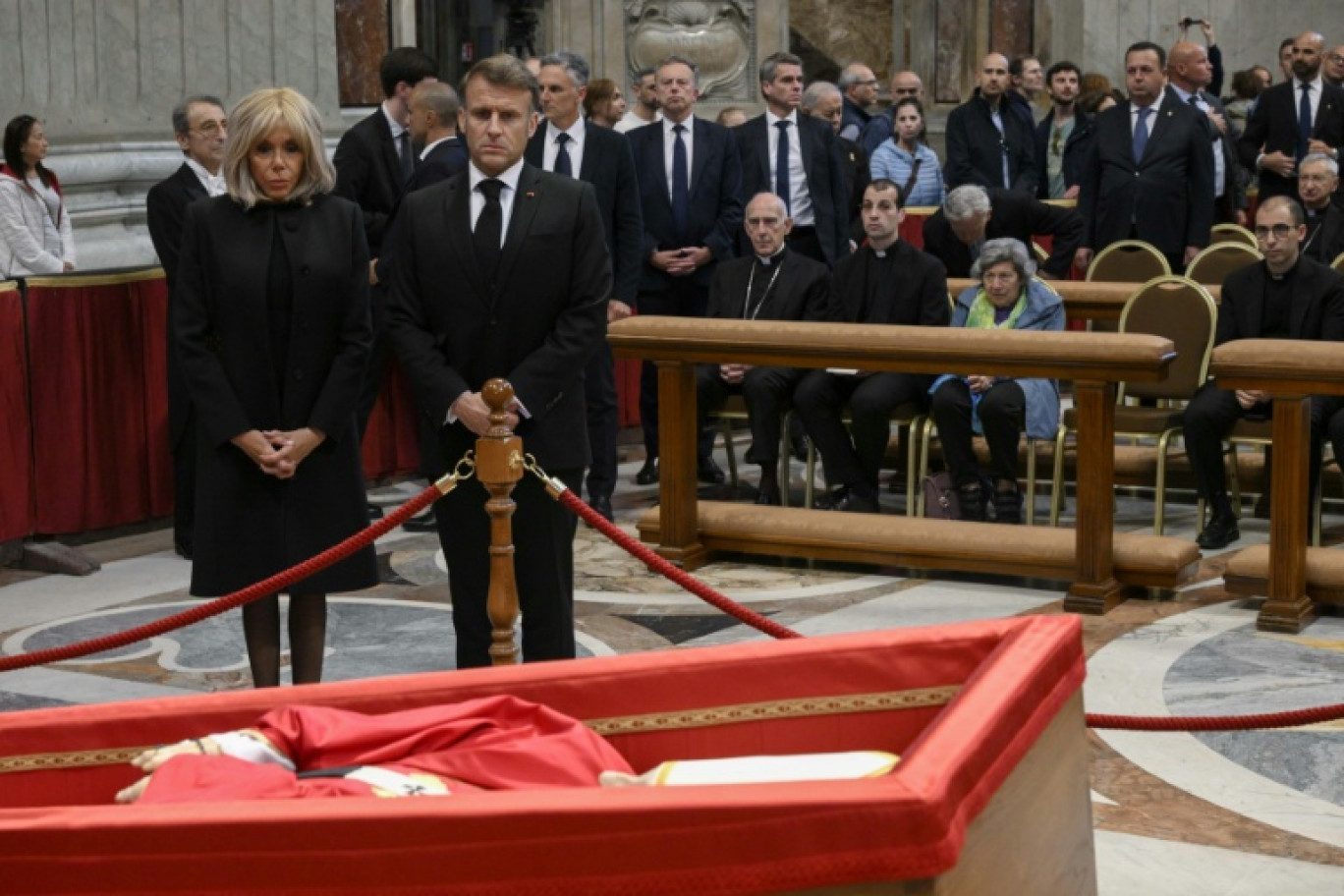 This photo taken and handout on April 25, 2025 by The Vatican Media shows France's President Emmanuel Macron and his wife Brigitte Macron paying their respects to Pope Francis at St Peter's basilica in The Vatican. © Handout