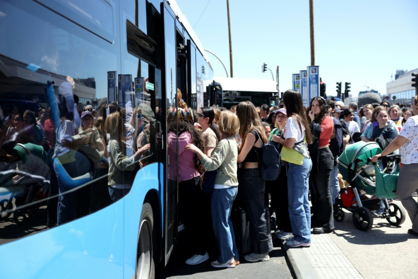 Des passagers montent à bord de bus de banlieue devant la gare d'Atocha à Madrid après sa fermeture suite à une panne de courant massive qui a frappé l'Espagne le 28 avril 2025 © Thomas COEX