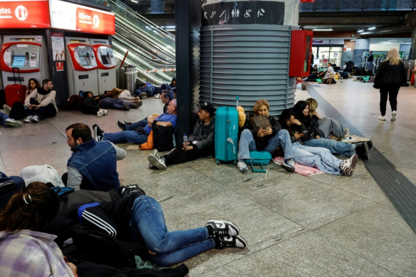 Des voyageurs se préparant à passer la nuit à la gare d'Atocha, à Madrid, à cause de la panne d'électricté géante, le 28 avril 2025 © Óscar del Pozo