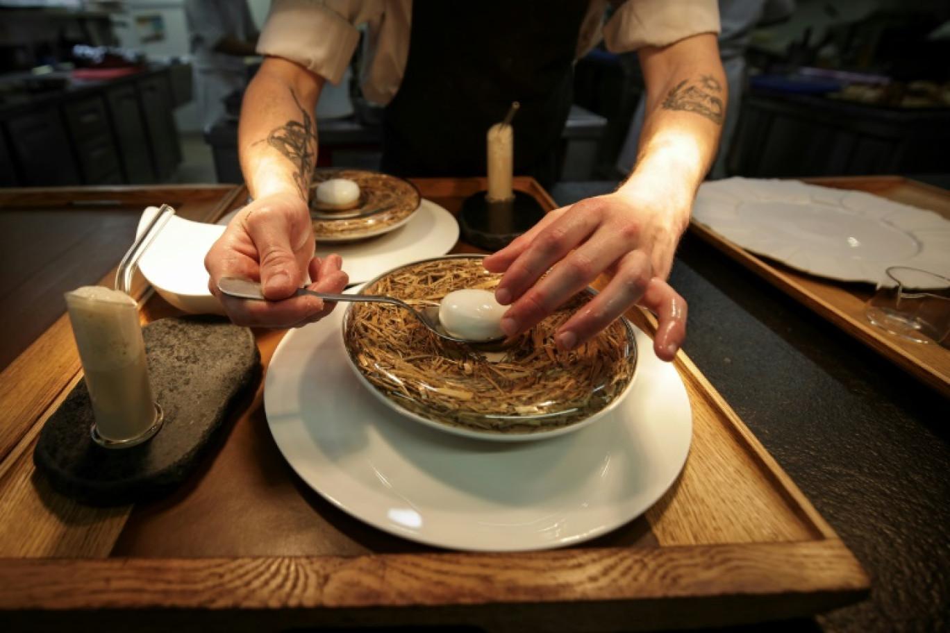 Un sous-chef prépare un plat emblématique du chef étoilé Gilles Goujon, l'œuf de poule "Carrus" pourri à la truffe, au restaurant "Auberge du Vieux Puits" à Fontjoncouse (Aude), le 25 avril 2025 © Valentine CHAPUIS