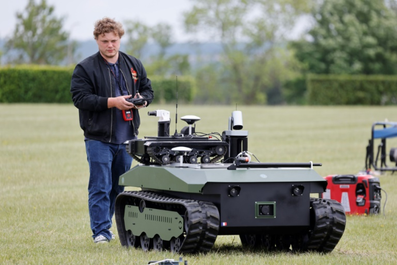 Un ingénieur effectue une démonstration d'un robot de combat lors du challenge CoHoMa, dans un camp d'entraînement militaire de la gendarmerie nationale, à Beynes, à l'ouest de Paris, le 6 mai 2025 © Ludovic MARIN