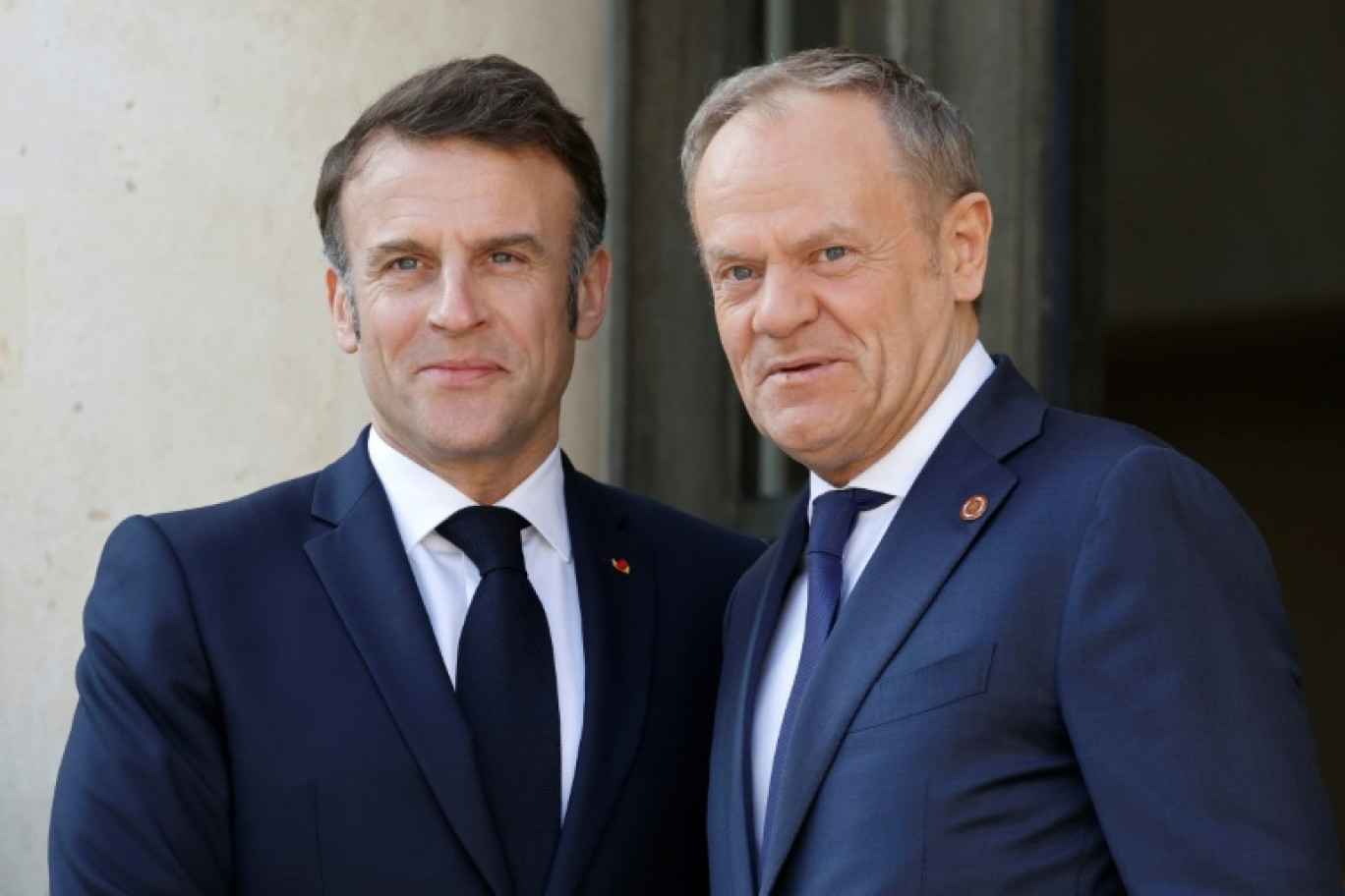 Le Premier ministre polonais Donald Tusk (g) et le président français Emmanuel Macron se serrent la main après avoir signé un traité à l'issue de leur rencontre à Nancy, le 9 mai 2025 © Christophe PETIT TESSON