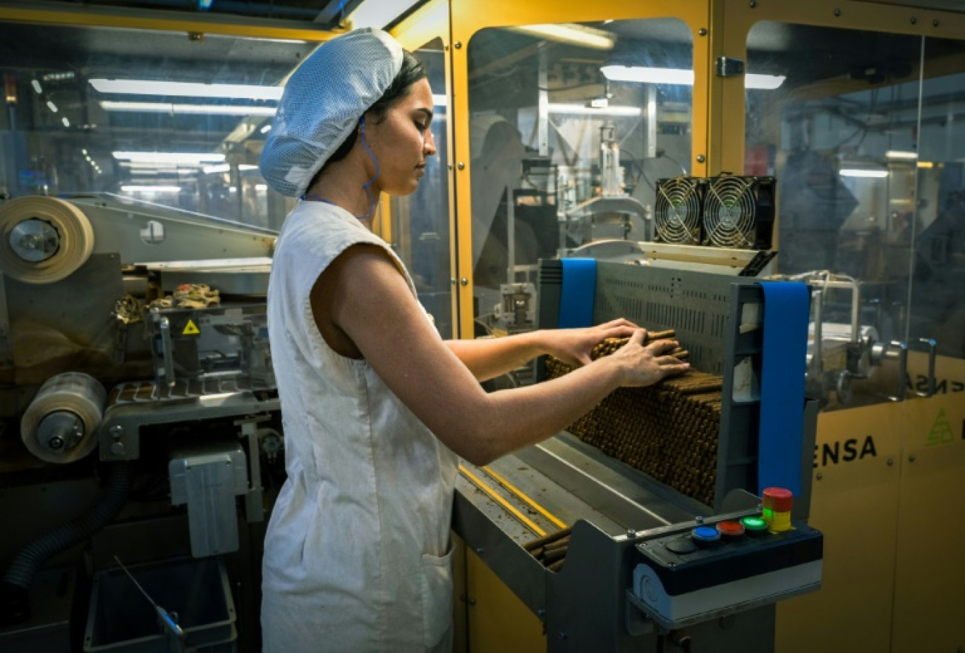 Une ouvrière travaille sur une machine pour confectionner des cigarillos dans l'usine ICT de La havane, le 8 mai 2025 © ADALBERTO ROQUE