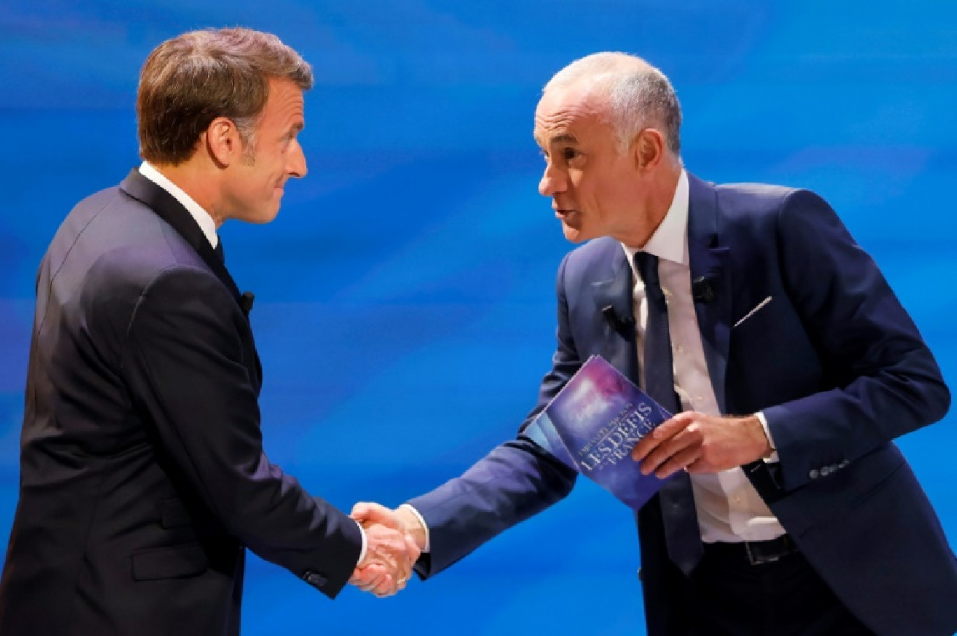 Emmanuel Macron accueilli mardi soir sur TF1 par le journaliste Gilles Bouleau (D) le 13 mai 2025. © Ludovic MARIN