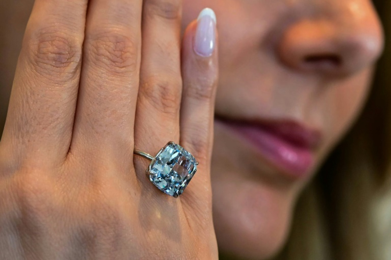 Le "Bleu Méditerranée", diamant de 10,03 carats, présenté le 8 avril 2025 à Abou Dhabi au doigt d'une employée de Sotheby's, avant sa vente aux enchères mi-mai à Genève en Suisse © Giuseppe CACACE