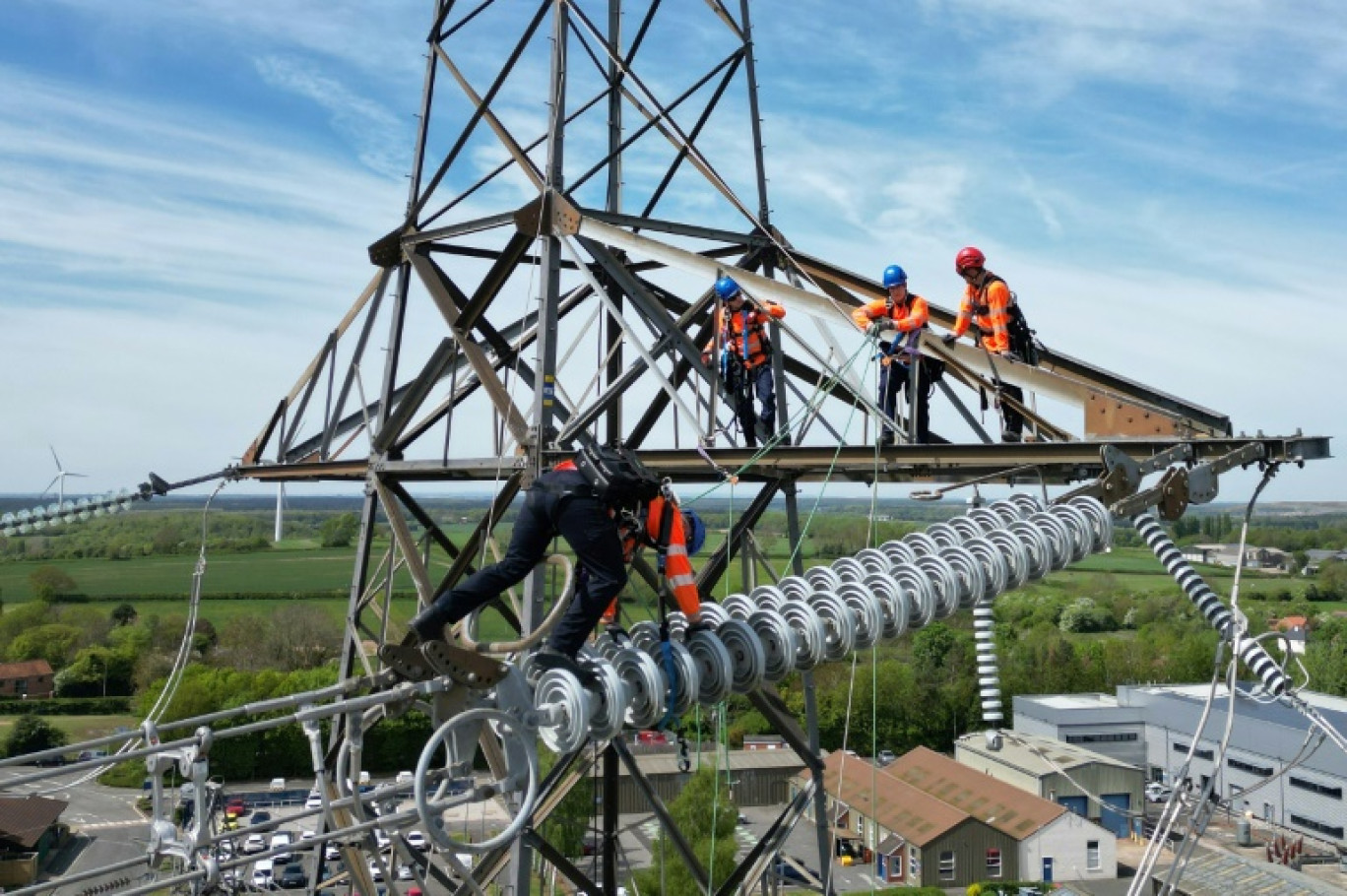Des apprentis suivent une formation sur un pylône au centre de formation de National Grid à Eakring, dans le centre de l'Angleterre, le 28 avril 2025, perchés à 45 mètres de hauteur © Darren Staples