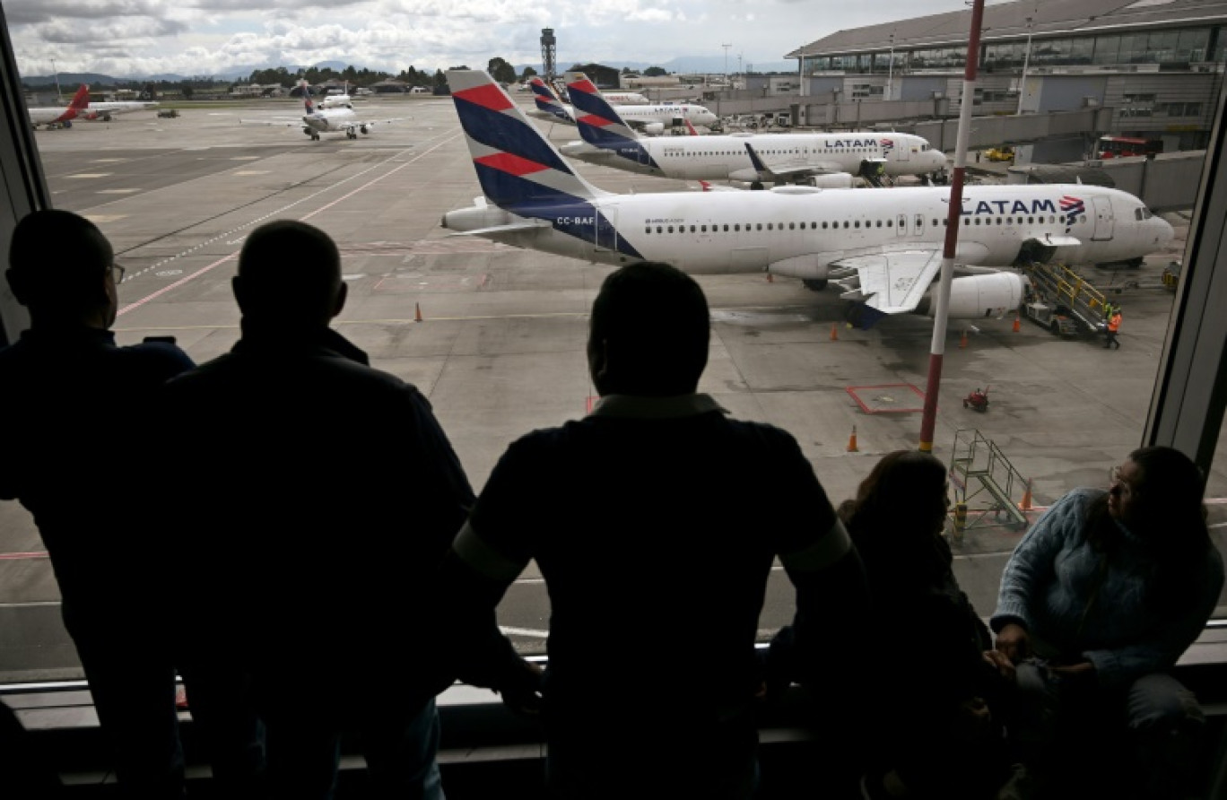 Des passagers vénézuéliens regardent des avions de la compagnie LATAM après l'annulation de leur vol pour Caracas, le 19 mai 2025 à l'aéroport El Dorado de Bogota © Raul ARBOLEDA