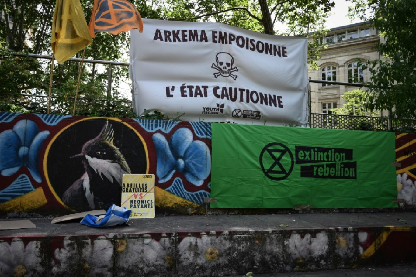 Une banderole indique "Arkema empoisonne, l'Etat soutient" lors d'un rassemblement devant le palais de justice de Lyon en soutien à des activistes poursuivis après une action anti-pollution en mars contre l'usine du chimiste Arkema, le 18 juin 2024 © JEAN-PHILIPPE KSIAZEK