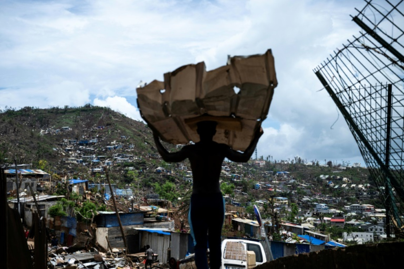 Un homme transporte des matériaux pour reconstruire sa maison à Mamoudzou, à Mayotte, le 2 janvier 2025 © JULIEN DE ROSA