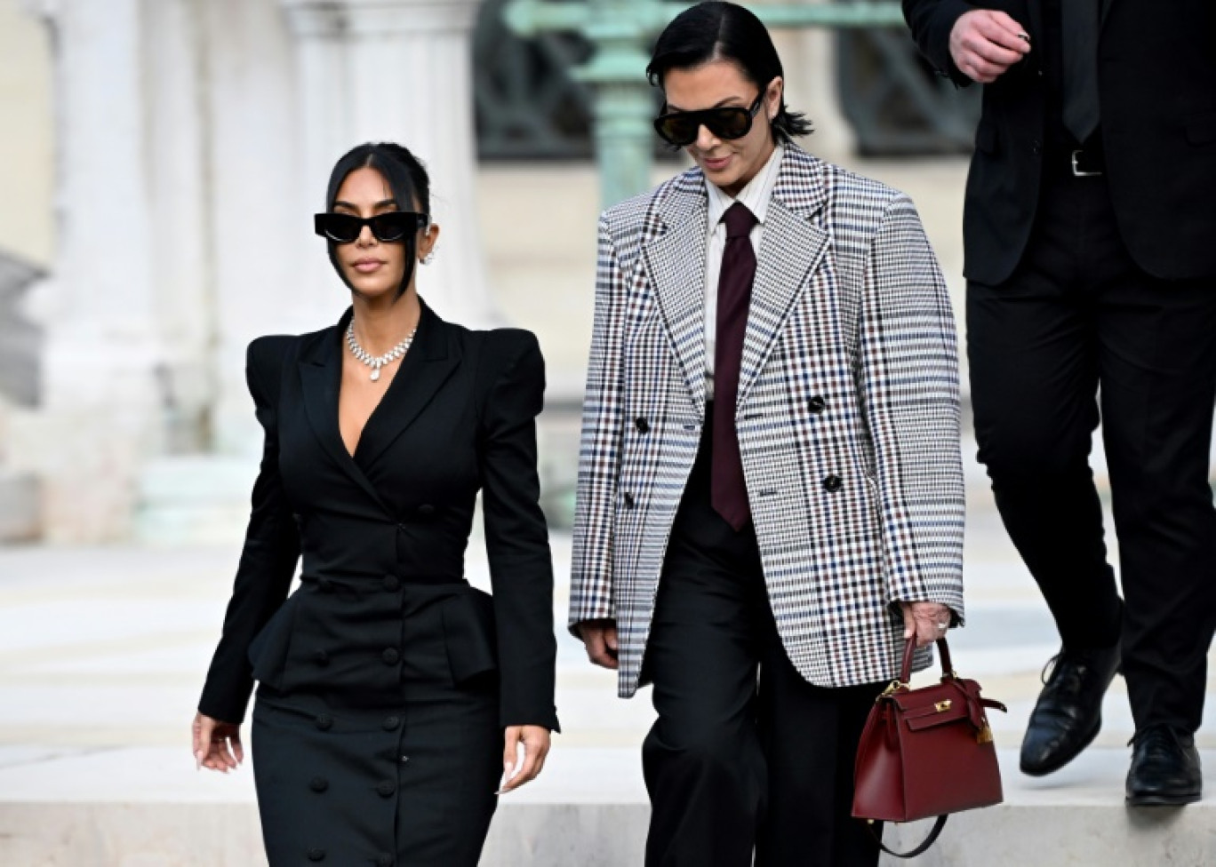 L'influenceuse américaine Kim Kardashian (c), accompagnée de sa mère Kris Jenner (d), quitte la cour d'assises de Paris, le 13 mai 2025, après avoir témoigné dans le procès du braquage dont elle a été victime en 2016 © LEO VIGNAL