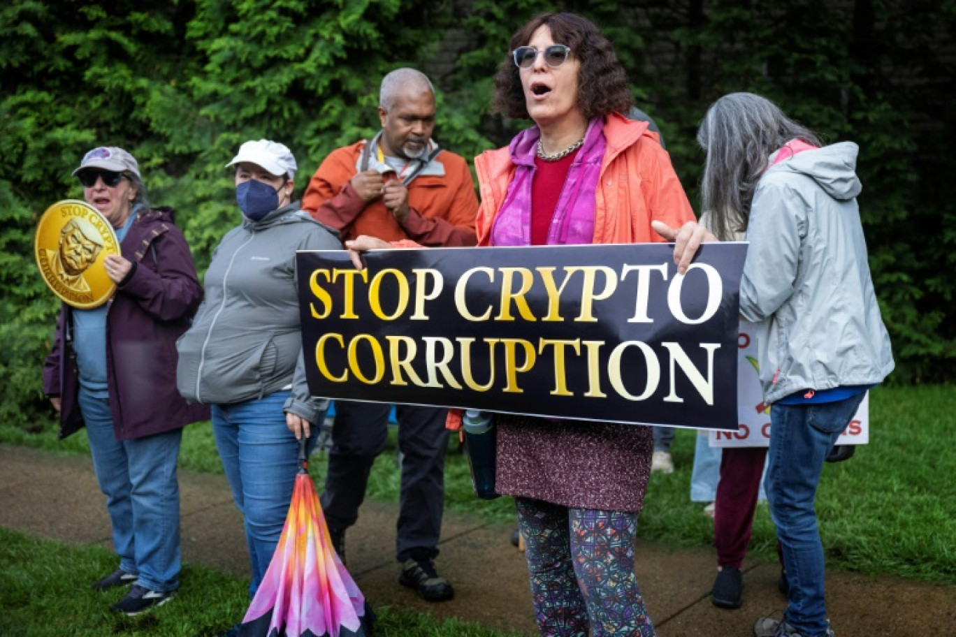 Des manifestants devant le Trump National Golf Course à Sterling, en Virginie, le 22 mai 2025, où le président Donald Trump participe à un dîner privé dans son club pour les 220 plus gros détenteurs de sa cryptomonnaie © Jim WATSON
