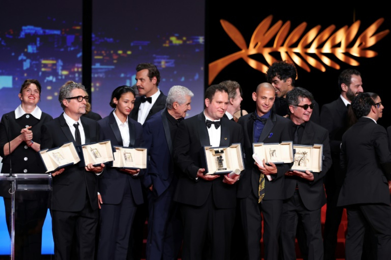 De g. à d.: Alice Rohrwacher, Kleber Mendonca Filho, Nadia Melliti, Laurent Lafitte, Claude Lelouch, Hasan Hadi, Tawfeek Barhom, Jafar Panahi, sur la scène du 78e festival de Cannes, le 24 mai 2025 © Sameer AL-DOUMY