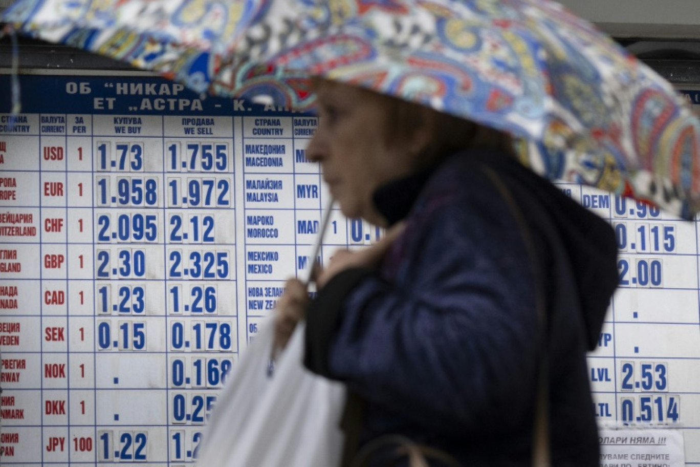 Une femme passe devant un bureau de change à Sofia, le 30 mai 2025 en Bulgarie © Nikolay DOYCHINOV
