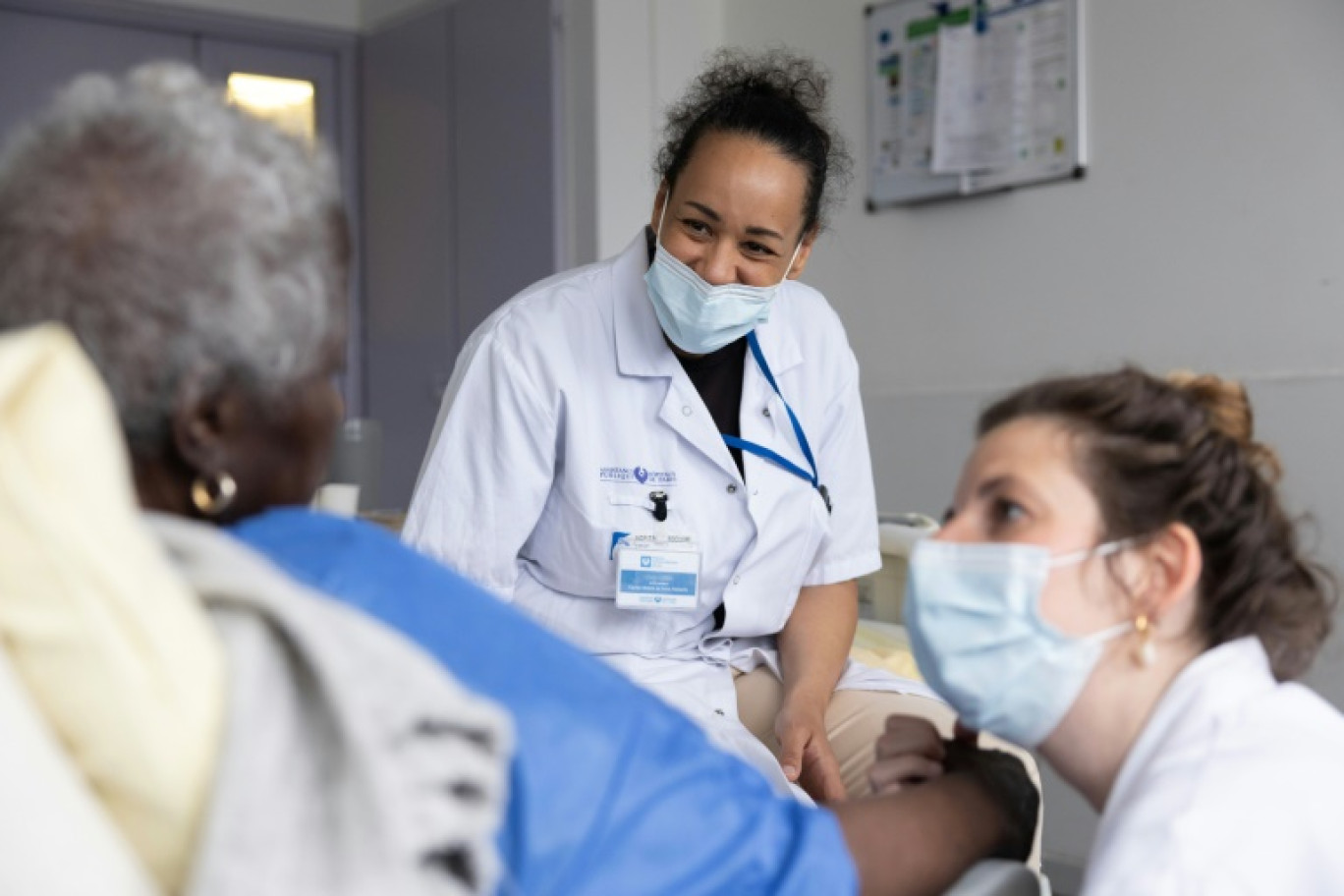 Une infirmière (à gauche) et une psychomotricienne (à droite) du service mobile de soins palliatifs au chevet d'une patiente à l'hôpital Antoine-Béclère de l'AP-HP, à Clamart, près de Paris, le 27 mai 2025 © Thomas SAMSON