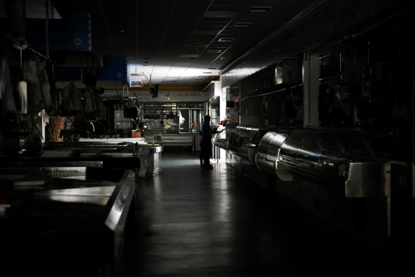 Un homme et un enfant dans un marché couvert plongé dans le noir lors de la panne électrique massive du 28 avril 2025, à Vigo, dans le nord-ouest de l'Espagne © MIGUEL RIOPA