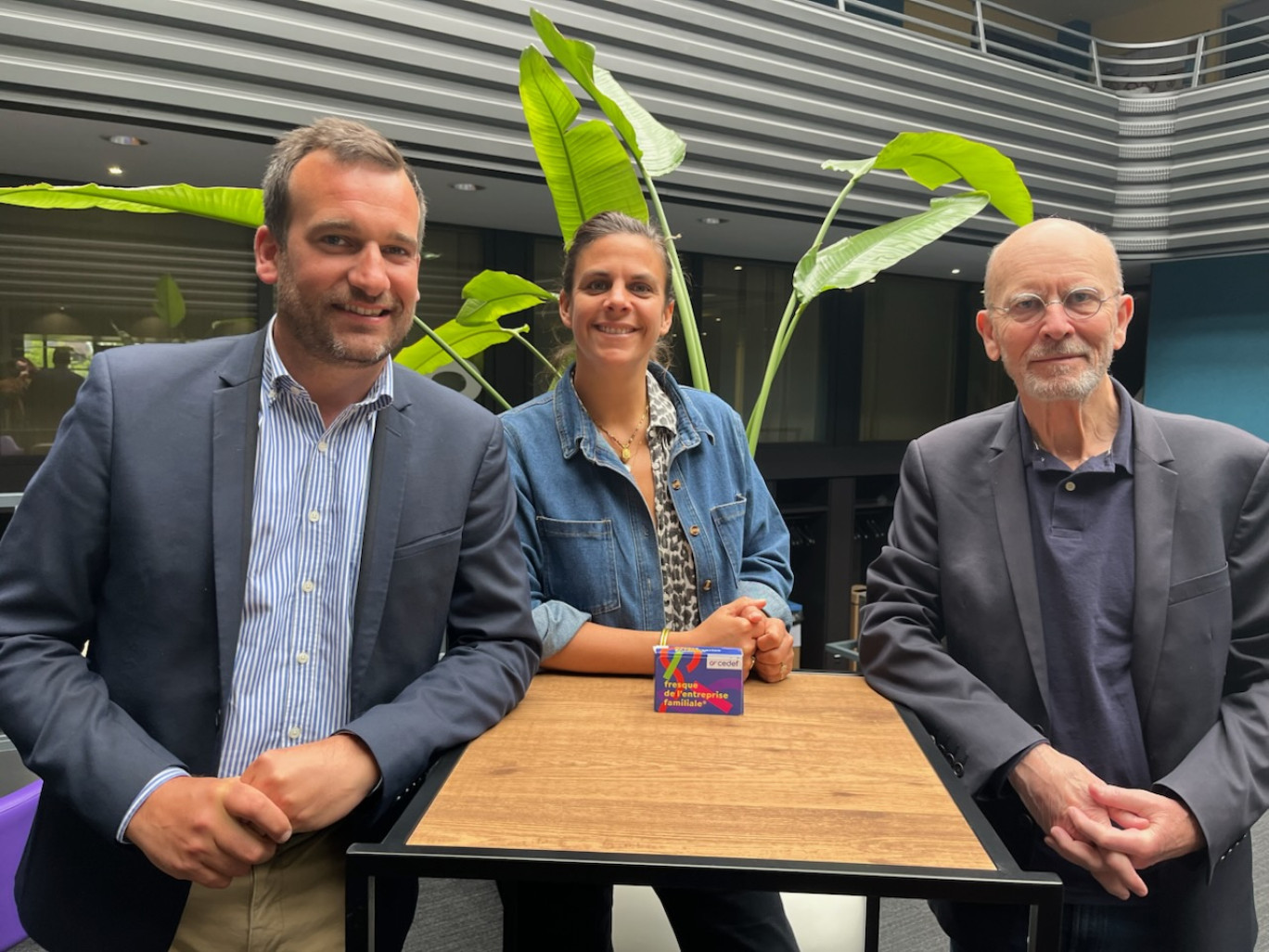 Amaury Lefort, Emilie Auvray et Alain Moy, avec la fresque de l'entreprise familiale.