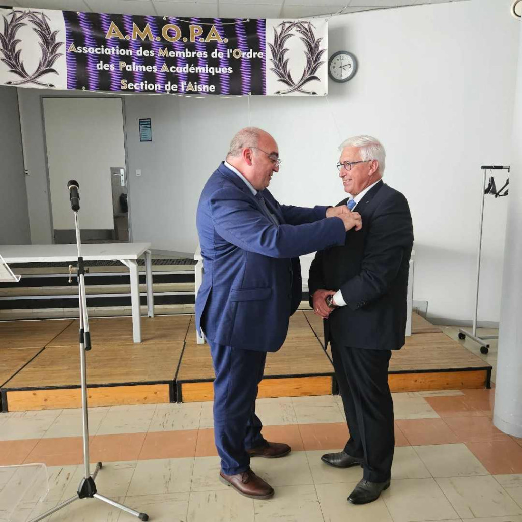 Jean-Marie Serre (à droite) épinglé par Patrick Engels, chef des travaux au lycée hôtelier Charles de Gaulle de Compiègne.