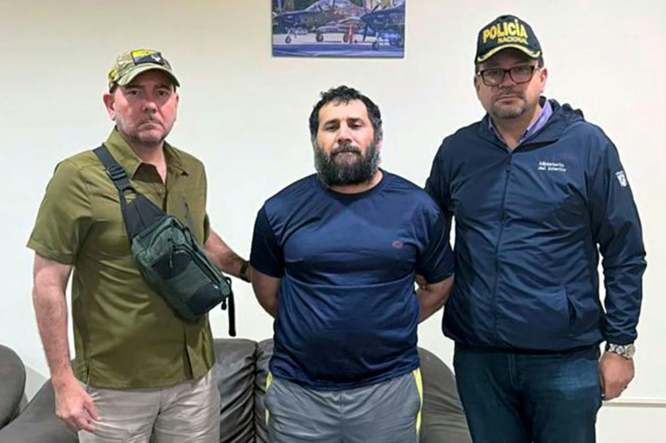 Sur cette photo diffusée par l'armée équatorienne, Adolfo Macias, alias "Fito" (centre), est entouré du ministre de la Défense Carlo Loffredo (gauche) et du ministre de l'Intérieur John Reimberg, le 25 juin 2025 à Manta (Equateur) © Handout
