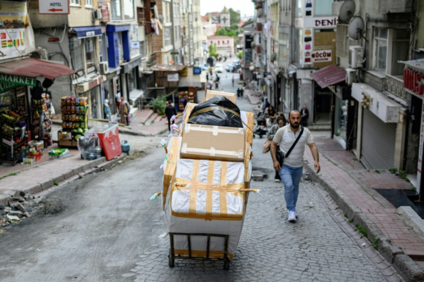 Un porteur pousse un chariot chargé de cartons dans le quartier de Laleli, à Istanbul, le 27 mai 2025 en Turquie © Yasin AKGUL