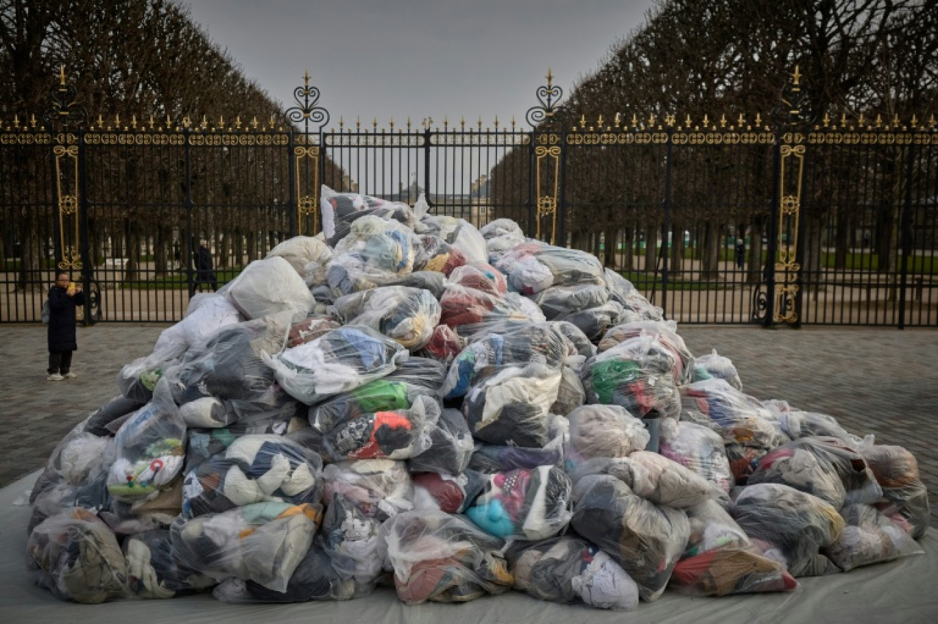 Des sacs de déchets textiles devant la porte du Palais du Luxembourg, où se trouve le Sénat lors d'une manifestation contre la fast-fashion, à Paris, le 14 mars 2025 © Kiran RIDLEY