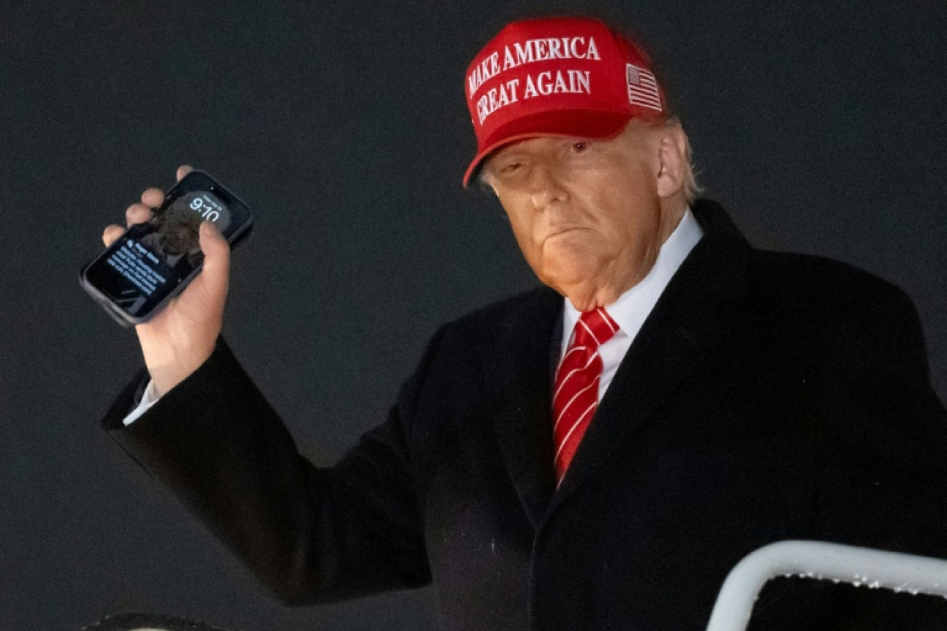 Le président américain Donald Trump, un smarthphone à la main, débarque d'Air Force à la base Andrews, dans le Maryland, de retour de Pennsylvanie où il a avoir visité une aciérie d'US Steel © SAUL LOEB