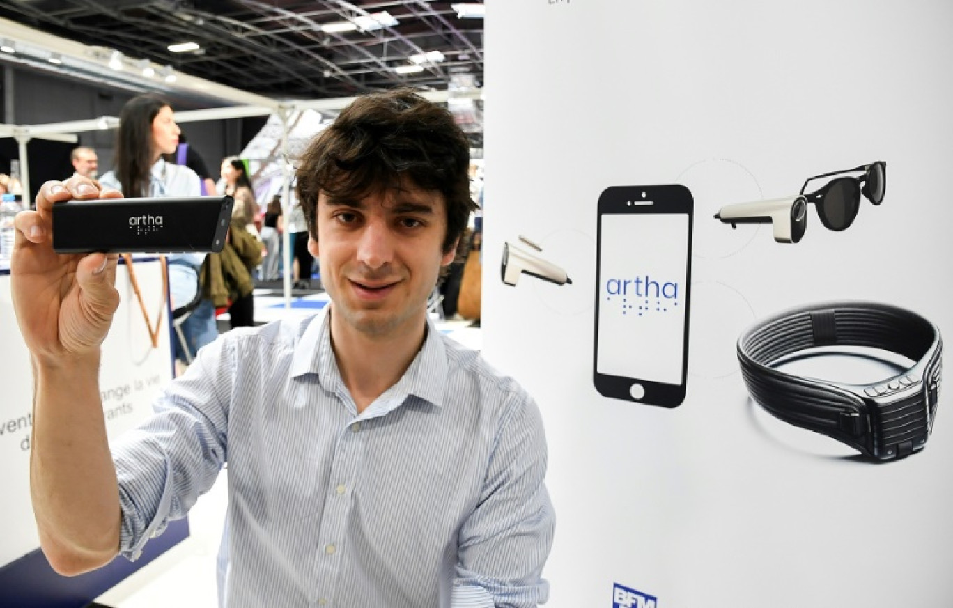 Fondateur français d'Artha France, Rémi Du Chalard présente une mini-caméra qui équipe une paire de lunettes et transmet des données visuelles sous forme de sensations tactiles via une ceinture lombaire à Paris le 10 mai 2024 © Mehdi FEDOUACH