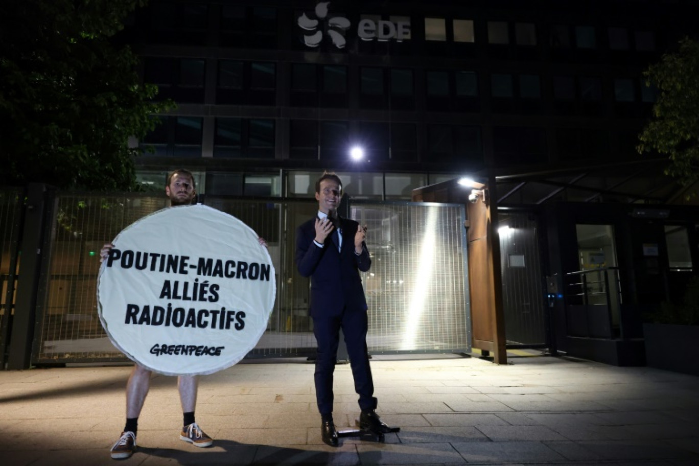 Un militant de l'ONG Greenpeace pose à côté de la statue en cire d'Emmanuel Macron le 3 juin 2025 devant le siège d'EDF à Paris © Xavier GALIANA