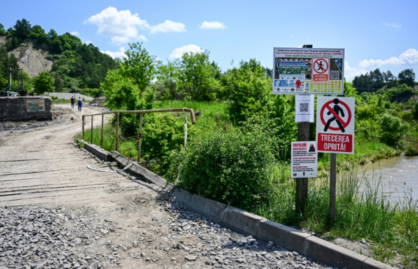 Panneaux "défense d'entrée" devant le pont enjambant la rivière Corund et menant à l'entrée de la mine de sel de Praïd, en Roumanie, le 3 juin 2025 © Daniel MIHAILESCU