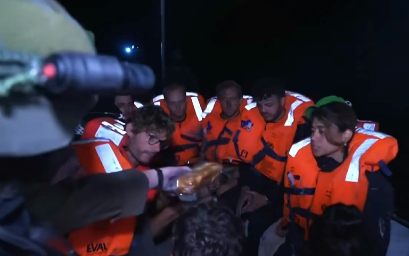 Image tirée d'une vidéo diffusée sur le compte X du ministère israélien des Affaires étrangères, le 9 juin 2025, montrant des passagers du bateau Madleen à destination de Gaza recevant des sandwichs après que le navire a été intercepté par les forces israéliennes dans les eaux internationales © -