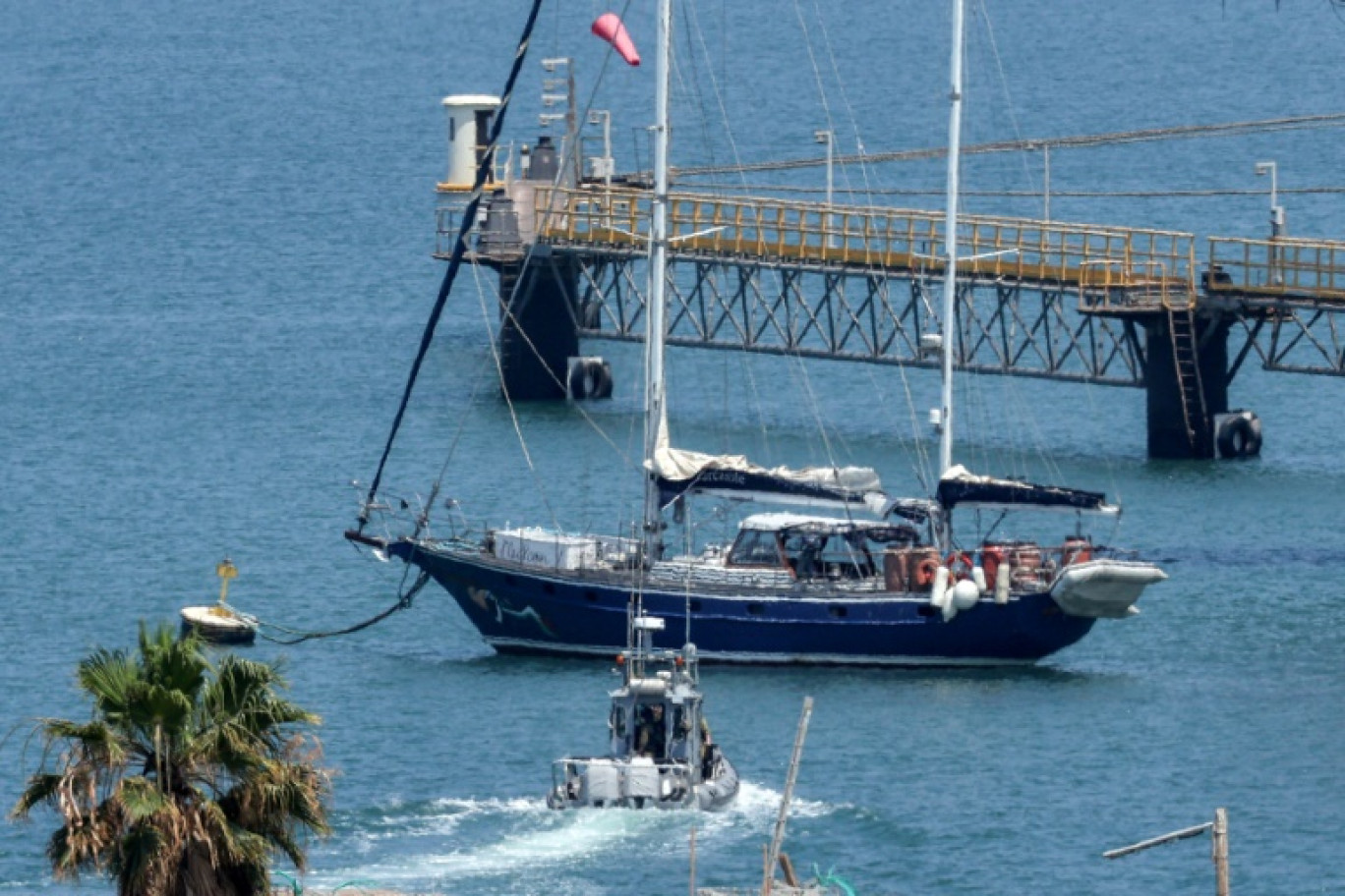 Un bateau de patrouille de la police israélienne se dirige le bateau Madleen amarré au port d'Ashdod après avoir été intercepté la veille par les forces israéliennes, le 10 juin 2025 © Jack GUEZ