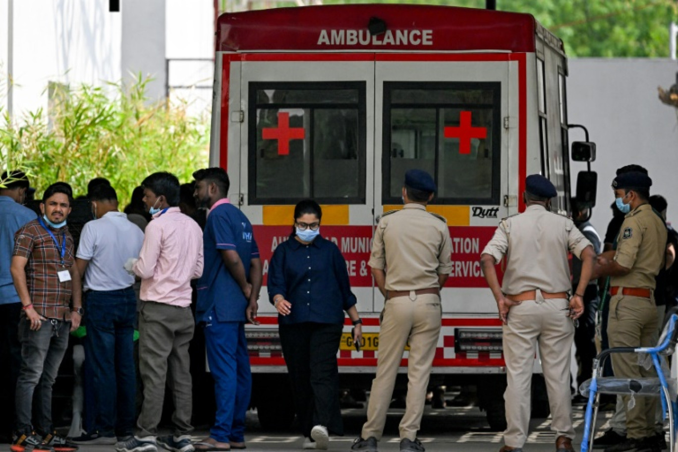Des policiers et des membres du personnel médical près d'une ambulance stationnée devant une morgue d'hôpital à Ahmedabad, le 15 juin 2025 © Punit PARANJPE