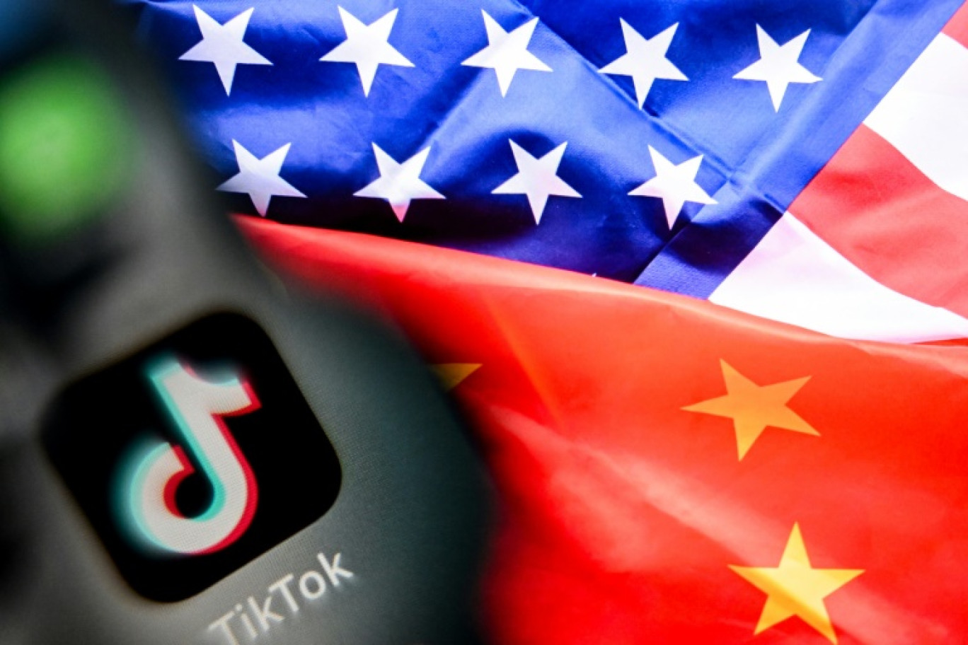 Logo du réseau social TikTok avec les drapeaux de la Chine et des Etats-Unis, le 10 avril 2025 © Kirill KUDRYAVTSEV
