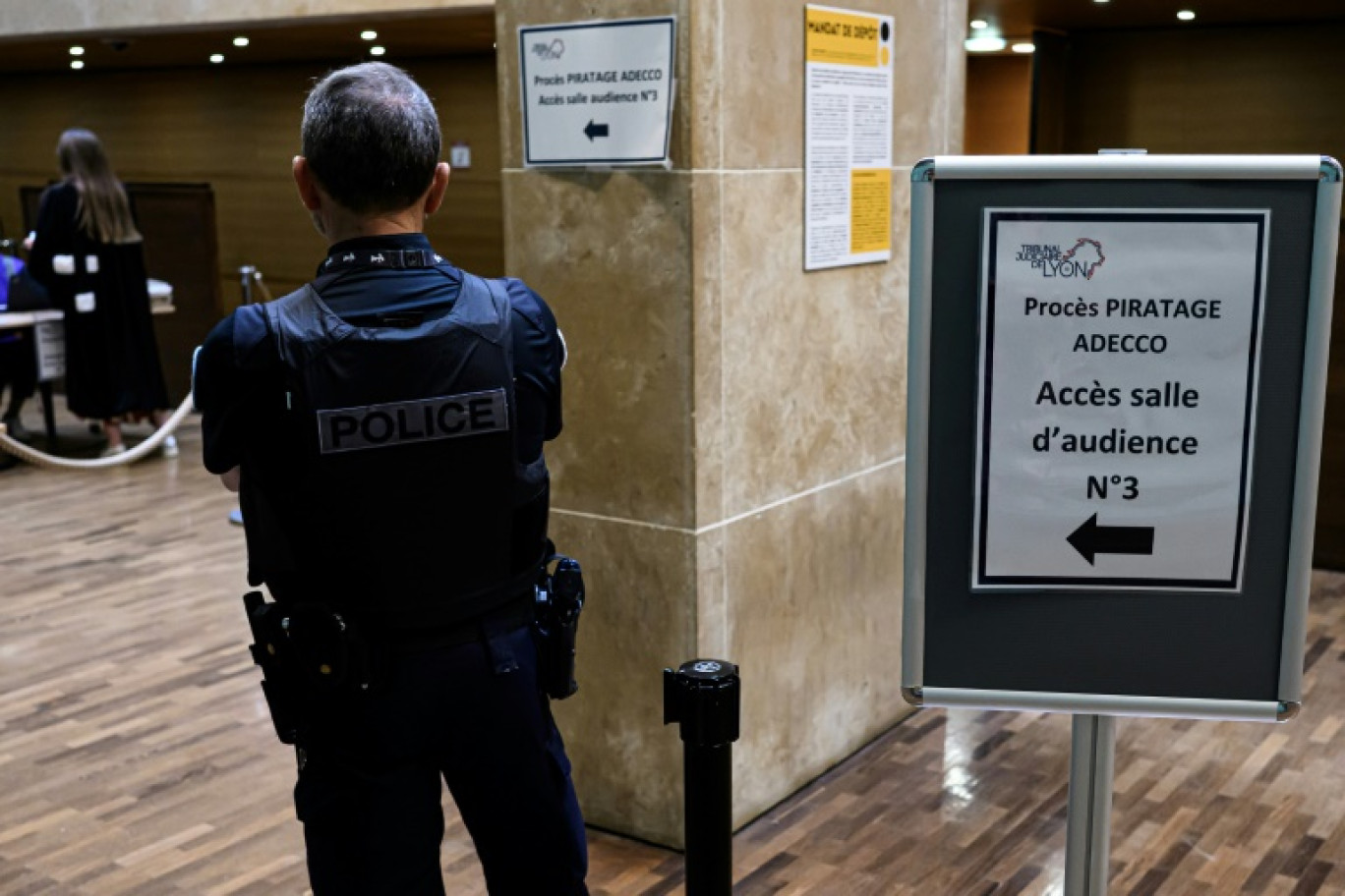 Un policier dans le hall du tribunal correctionnel de Lyon à l'ouverture du procès de piratage massif des donnée d'Adecco, le 16 juin 2025 © JEAN-PHILIPPE KSIAZEK