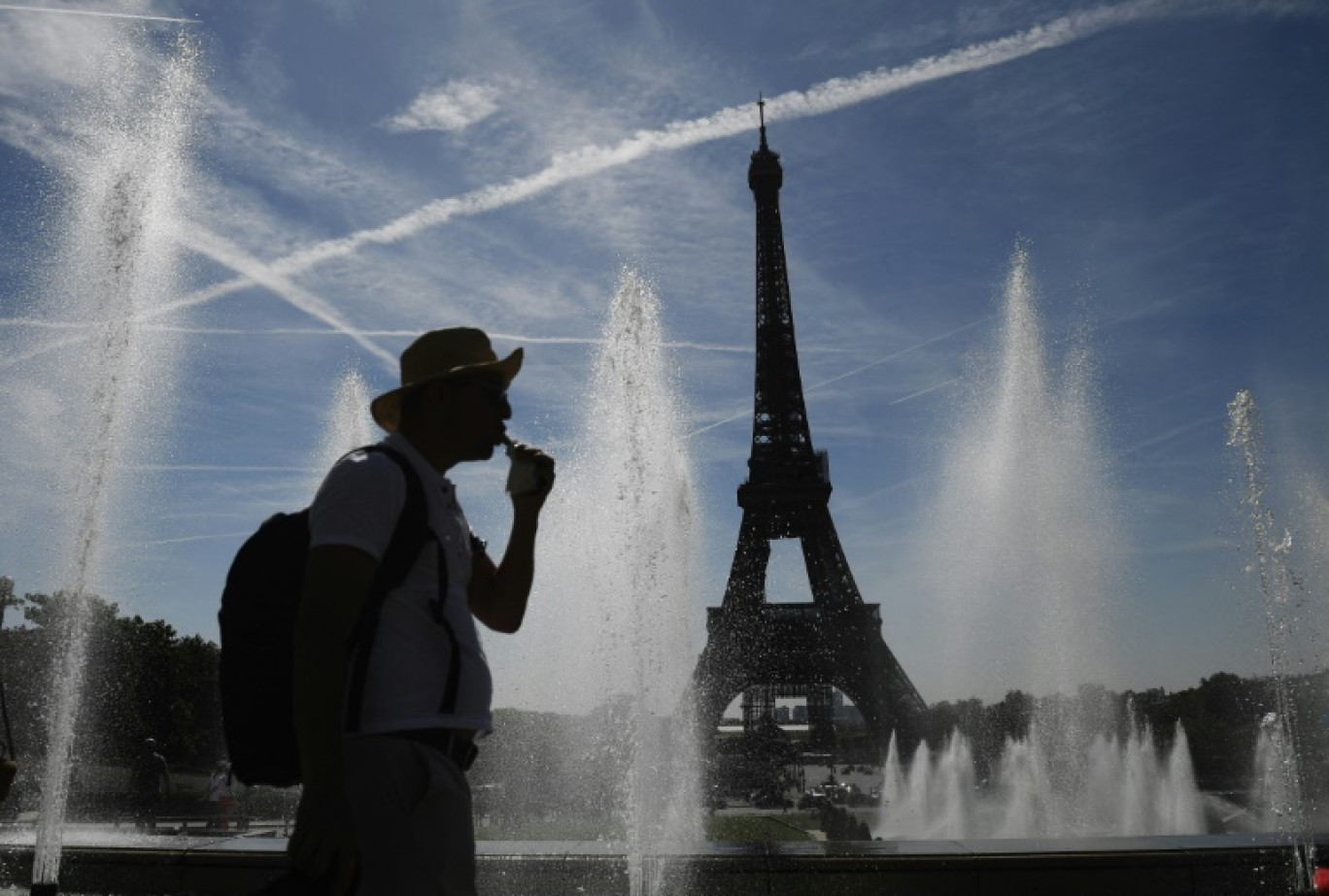 Un homme se rafraîchit près de fontaines à Paris le 16 juin 2022 © JULIEN DE ROSA