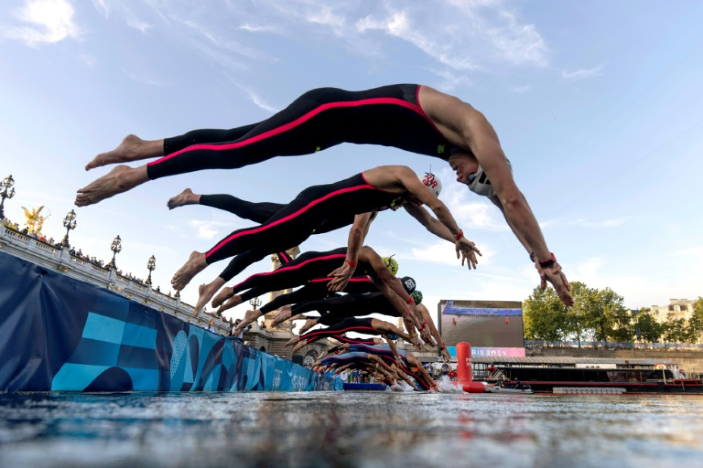 Des athlètes plongent dans la Seine depuis le pont Alexandre III à Paris pour prendre le départ de la finale masculine du marathon de natation de 10 km aux Jeux Olympiques de Paris 2024, le 9 août 2024 © David Goldman