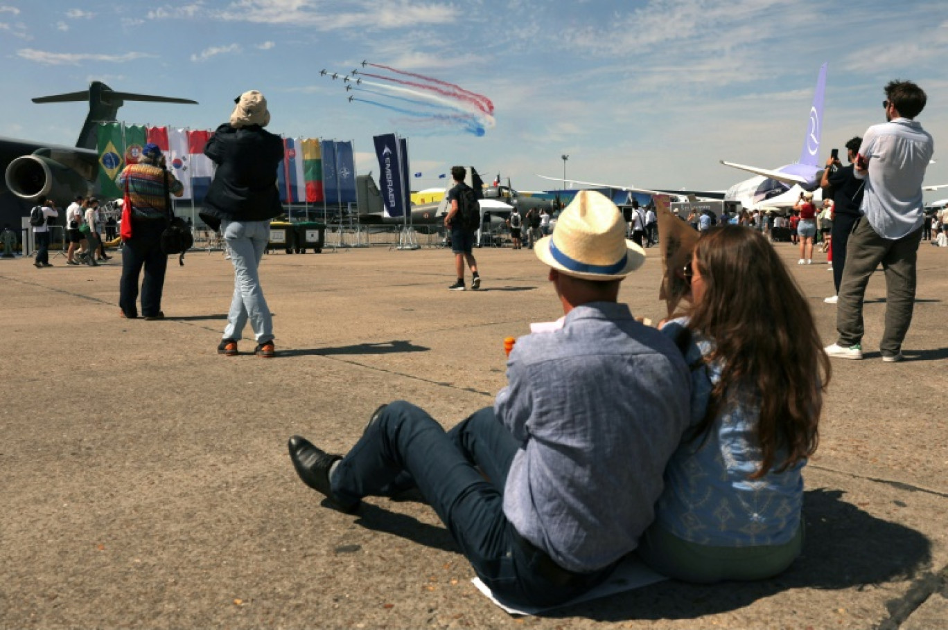 Des visiteurs regardent des avions de la patrouille de France pendant la 55e édition du Salon international de l'aéronautique et de l'espace à l'aéroport du Bourget, au nord de Paris, le 20 juin 2025 © Thomas SAMSON