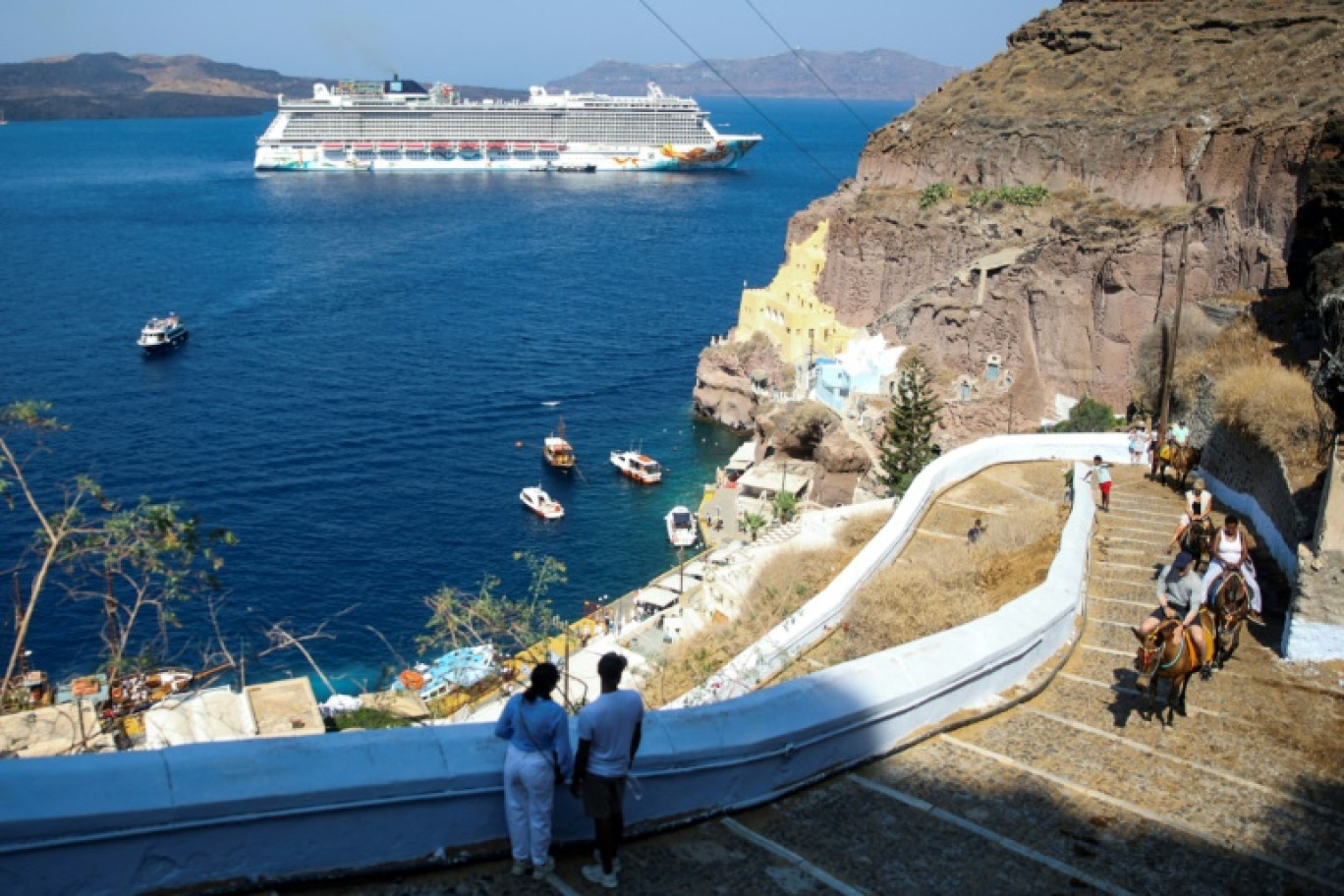 Un bateau de croisière près de la ville de Fira, sur l'île grecque de Santorin, le 20 juillet 2024 © ARIS OIKONOMOU