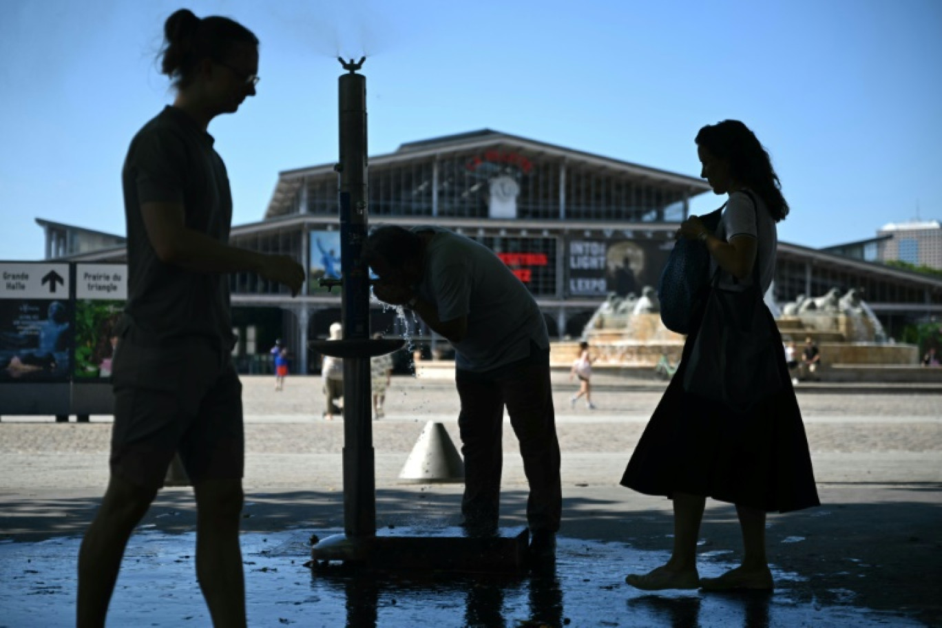 Des personnes se rafraîchissent à une fontaine publique près de la Grande Halle de La Villette alors qu'une vague de chaleur frappe le sud de l'Europe, à Paris, le 29 juin 2025 © Julie SEBADELHA