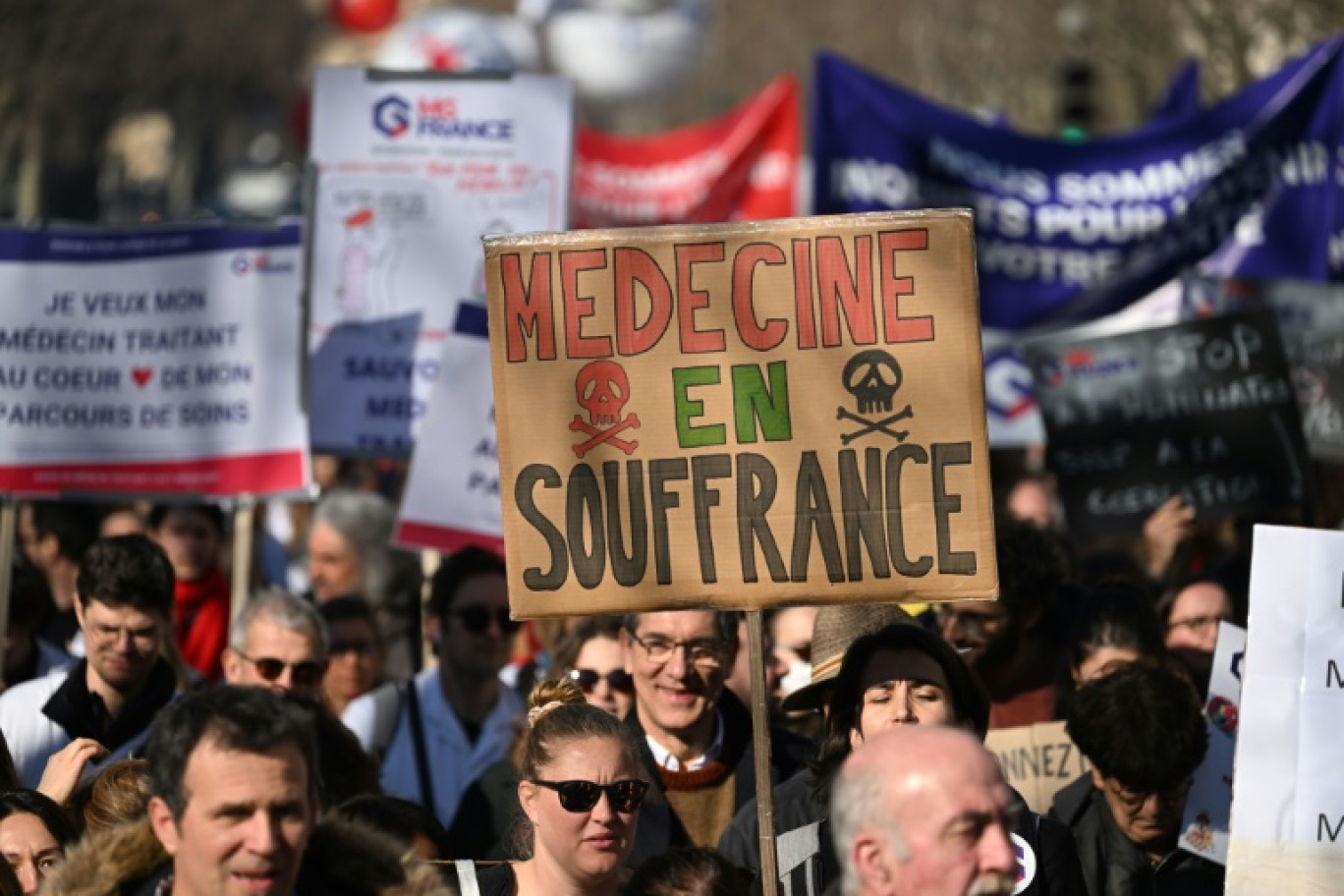 Un manifestant brandit une pancarte "Médecine en souffrance" lors d'une mobilisation du secteur privé, le 14 février 2023 à Paris © Emmanuel DUNAND