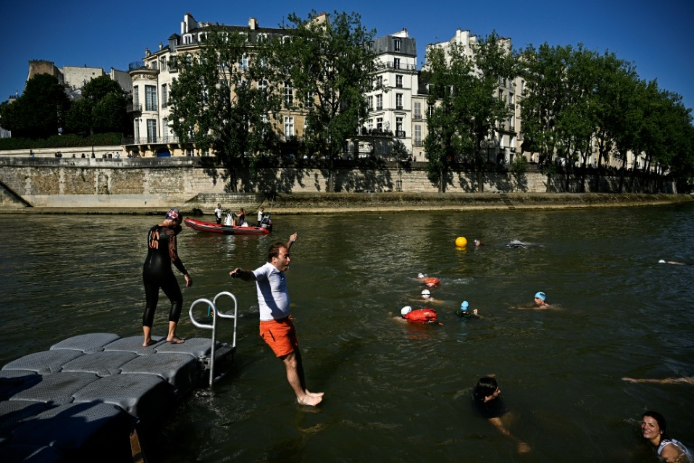 Un riverain se jette à l'eau dans la Seine au bras Marie, le 17 juillet 2024 © JULIEN DE ROSA