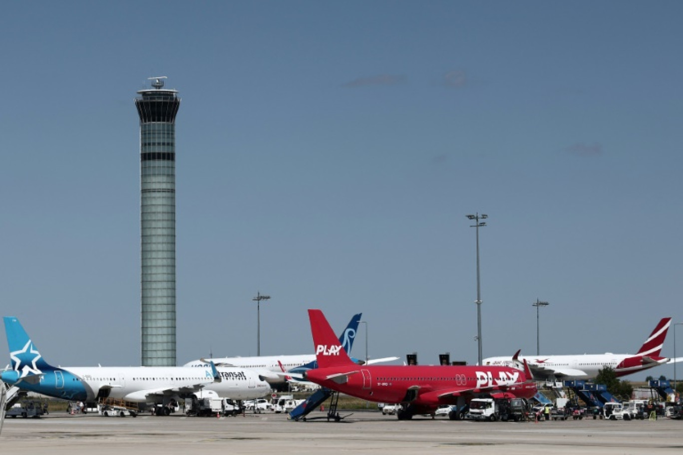 Des passagers consultent le tableau d'affichage des départs à l'aéroport Roissy Charles-de-Gaulle, près de Paris, pendant la grève des contrôleurs aériens français, le 3 juillet 2025 © Thibaud MORITZ